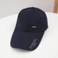 Detailed view of dark blue baseball cap with extended brim, metal sport badge and print. - Adjustable / Navy Blue