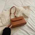 Brown underarm shoulder bag with metal bow accent, stylish fashion baguette crossbody bag for women - Brown