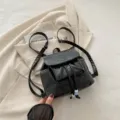 Petit sac à dos noir en cuir synthétique pour femme avec cordon de serrage et poche. - Noir