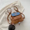 Mini sac à dos rétro en similicuir marron avec rabat en jean bleu et cordon de serrage chic. - Marron