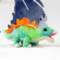 Niedlicher gruen blauer Pluesch Dinosaurier Spielzeug Puppe mit orangen Rueckenplatten. - Stegosaurus Puppe