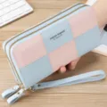 Detail view of the women's colorblock long wallet with double zippers and practical wrist strap. - Pale Blue