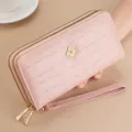Close-up view of pink double zipper long wallet featuring chic metallic clasp and wrist strap. - Pink