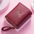 Red short trifold women wallet with wrist strap and cute rabbit metal decor for daily use. - Red