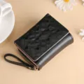 Short black quilted wallet with heart embroidery, card slots, zipper and snap button. - Black