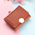 Compact brown crocodile texture short wallet with metal kiss-lock coin pocket and snap closure. - Camel