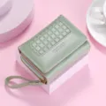 Green short women's wallet with grid embossed pattern, compact design and convenient wrist strap. - Green