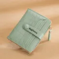 Women's short bi-fold wallet with crocodile pattern embossing, card slots, and zip coin pocket. - Green