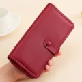 Close-up detail of wine red long leather wallet featuring multiple card slots. - Red