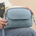 Light blue quilted crossbody bag for women, chic embroidered bow design with zipper. - Blue