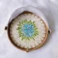 Detail view of handmade rattan fruit basket with colorful seashell mosaic and white net. - Blue Heart Shell Mesh