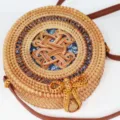Close-up detail of hand-woven round rattan bag with brown leather strap and floral lining. - Blue Stone No.2