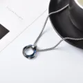 Close-up detail of interlocking three-ring titanium steel pendant necklace on white surface. - 70cm / Blue