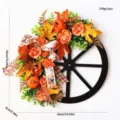 Autumn wagon wheel wreath with pumpkins, artificial roses, maple leaves, and plaid ribbon decor. - Wagon Wheel Wreath