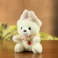 Cute plush teddy bear pendant with pink bow and strawberry charm, soft toy keychain accessory. - Beige