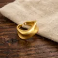 Detailed view of a minimalist irregular geometric open ring with matte frosted finish texture. - Frosted Matte Gold Streamline Style (JZ5601-2) / Open Adjustable