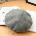 Close-up detail of grey wool beret featuring metal ring accents and soft textured fabric. - M (56-58cm) / Light Gray