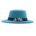 Nahaufnahme des eleganten türkisfarbenen Filzhutes mit feinen Perlen und Blumenverzierungen. - Seeblau