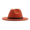 Nahaufnahme Detail des leuchtend orangefarbenen Fedora Hutes mit schwarzem Ledergürtel. - Orange
