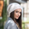 Gros plan d'un bonnet en tricot blanc doux et duveteux porté en extérieur, style d'hiver. - Taille unique / Crème