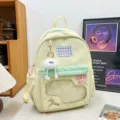 Cute low-saturation yellow student backpack with clear window, furry pendant and plaid patch. - Long Legged White Fur Ball / Green