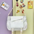 White canvas messenger bag with star print, adjustable strap, and front buckle pockets. - No Pendant / White