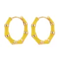 Detail view of yellow bamboo hoop earrings, elegant enamel metal jewelry design style. - Yellow