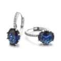 Detailaufnahme silberner Creolen mit ovalem blauen synthetischen Saphir und Zirkonia. - Blau