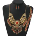 Detailed view of retro ethnic jewelry set showcasing intricate gold metalwork and red beaded design. - Antique Gold Red
