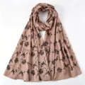 Close up detail of the pink imitation silk long scarf featuring elegant black floral print. - Pink