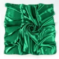 Dettaglio ravvicinato del foulard quadrato in raso verde con texture morbida e lucida. - Verde