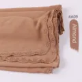 Gedetailleerd overzicht van geborduurde chiffon hijab sjaal met elegante kanten rand. - Amandel