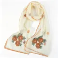 Close up detail of women embroidered mesh scarf with pearls and elegant orange scalloped edge. - Beige