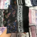 Detailed view of black floral print voile hijab scarf, showcasing fine fabric texture. - 13