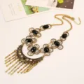 Detailed view of vintage brass resin rhinestone floral bib necklace, elegant bohemian statement jewelry. - Antique Gold