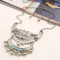 Close-up detail of vintage silver-tone peacock necklace and earrings set with turquoise beads. - Antique Silver & Blue