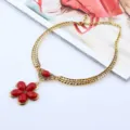 Nahaufnahme Detail der goldenen Vintage Kette mit rotem rissigen Stein Blumen Anhänger. - Antik Gold Rot
