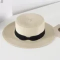 Detail view of a Korean style flat-top straw hat with a black bow ribbon for summer sun protection. - M (56-58cm) / Khaki