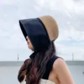 Detailed view of women's two-tone sun protection bucket hat featuring a stylish straw crown. - M (56-58cm) / Black Splicing