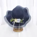 Détail de chapeau de paille bleu marine, avec décoration florale et large bord en filet ondulé. - M (56-58cm) / Bleu marine