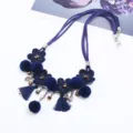 Navy blue suede cord necklace with fabric flowers, pom poms, and tassels for women. - Blue