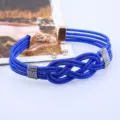 Detailaufnahme einer blauen geflochtenen mehrsträngigen Kette mit Strass-Knoten und Ohrringen. - Blau