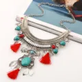Detailed close-up view of vintage bohemian turquoise tassel statement necklace with silver filigree. - Red