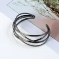 Detailansicht eines mehrsträngigen offenen Armreifs aus Metall in dunklem Gunmetal-Finish. - Gunmetal-Schwarz