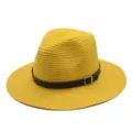 Gedetailleerd overzicht van een stijlvolle gele strooien fedora hoed met zwarte riem en gesp. - M (56-58cm) / Geel
