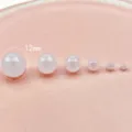 Detailed close-up of milky white acrylic round beads with straight holes in size comparison. - 12mm / Milky White