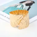 Detailed view of the wide gold plated metal leaf cuff bracelet, highlighting unique patterns. - Gold
