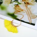 Detailansicht der langen Pulloverkette im Boheme-Stil mit goldenem Ring und gelben Quasten. - Gelb
