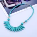 Gros plan sur le collier de perles turquoises bohème avec des intercalaires argentés. - Bleu