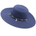 Gros plan détaillé du chapeau de paille bleu avec perles en bois et breloques de plumes. - M (56-58cm) / Bleu marine